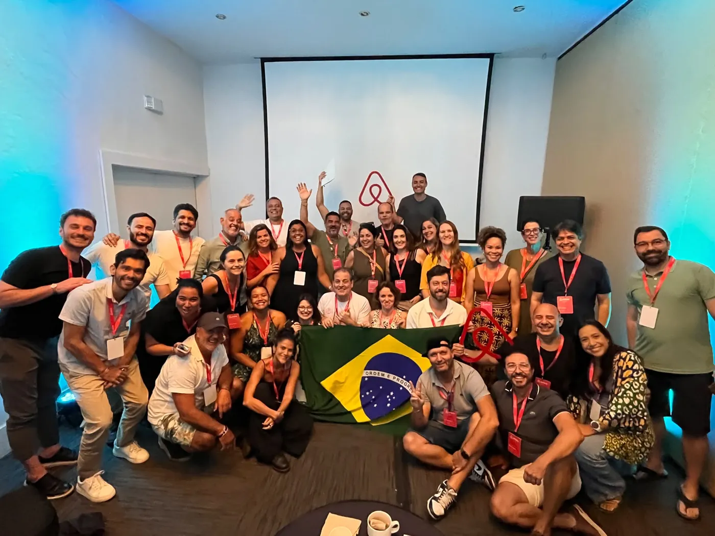 Delegação brasileira com a bandeira do Brasil no Airbnb Community Leader Summit 2026